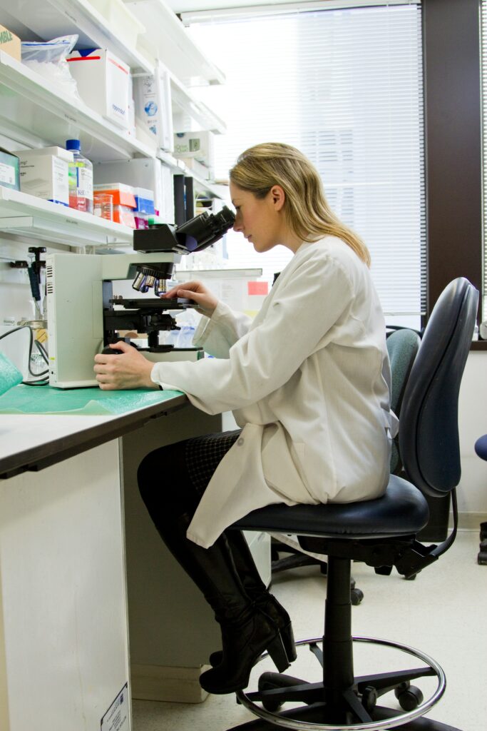femme scientifique regarde un microscope