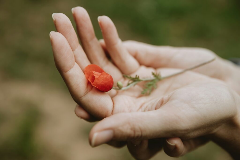 Une femme tenant une fleur à la main